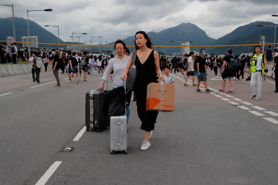  Passengers walk to the airport as pro-democracy protesters blocked roads