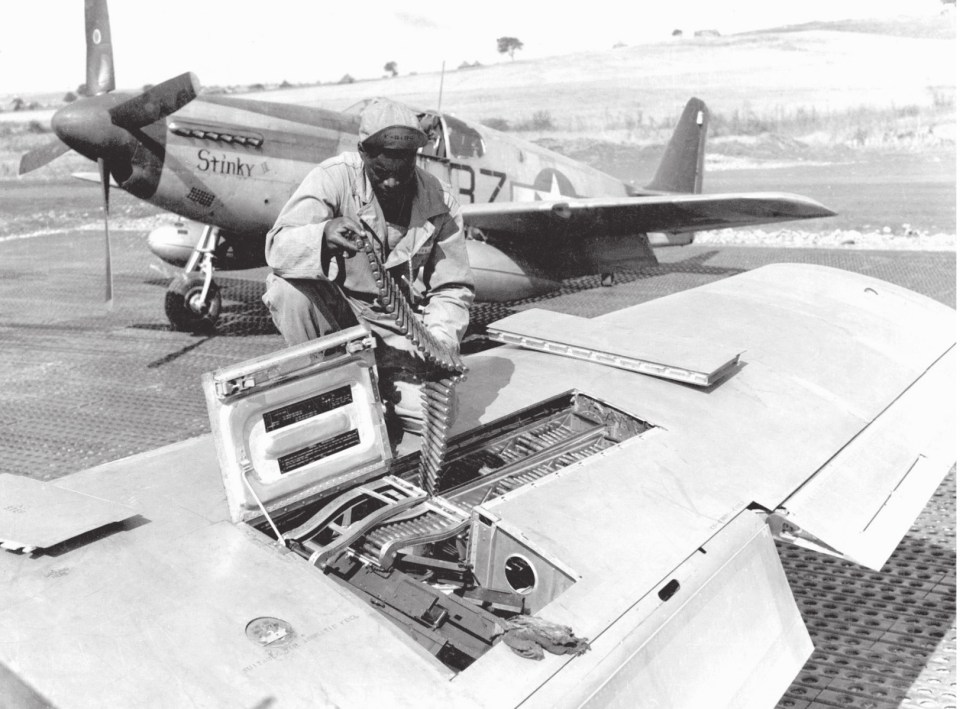  An American armourer loads the machine guns on a North American P-51B Mustang Fighter stationed in Italy