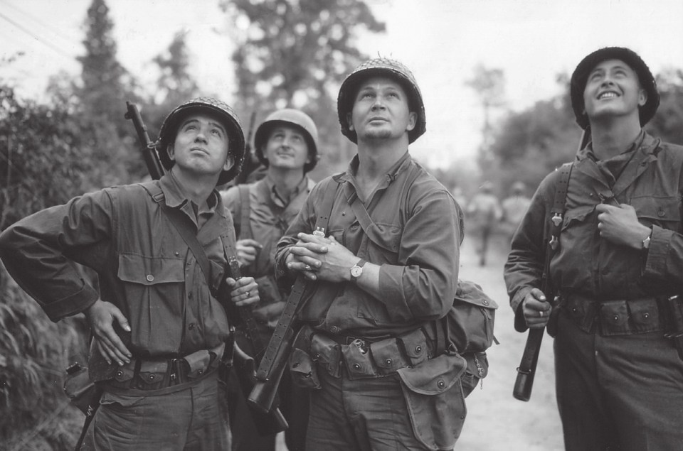  American GIs look to the skies with relief as they see allied planes