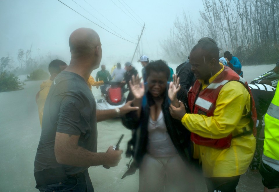  A visibly distressed woman is helped to safety in Freeport, Grand Bahama