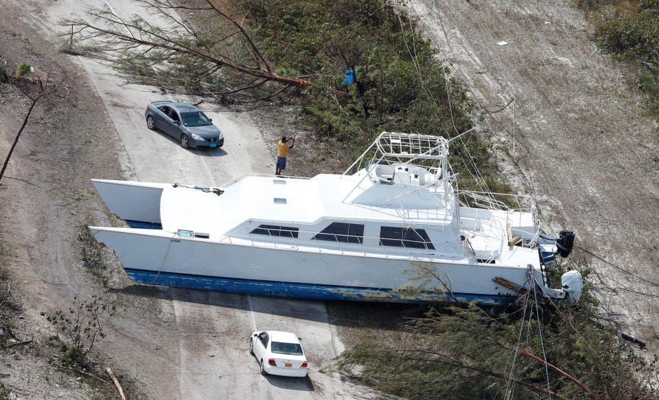  A boat is seen having been swept onto land