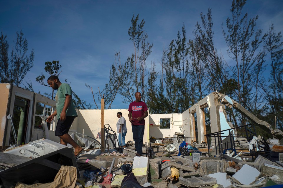  Resident George Bolter, left, walks through the remains of his destroyed home with his parents