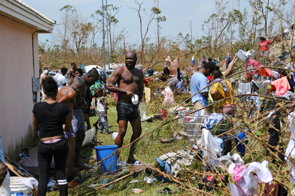  People wash themselves amidst the wreckage after being left with nothing