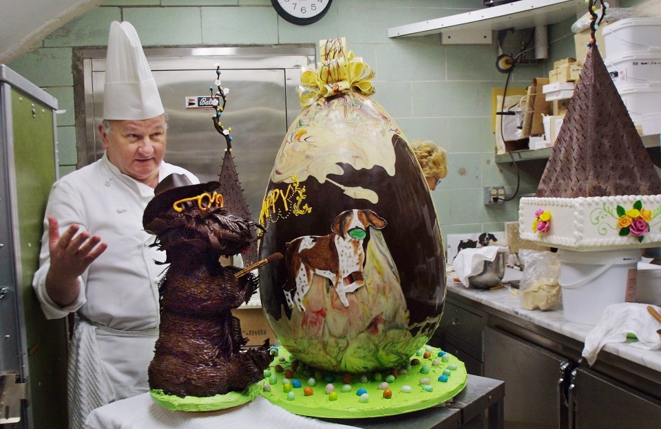 Pastry chef Roland Mesnier stands in the Chocolate Shop in March 2002 beside his impressive creation – a 40lb chocolate Easter egg, decorated with then-First Family dogs Barney and Spot