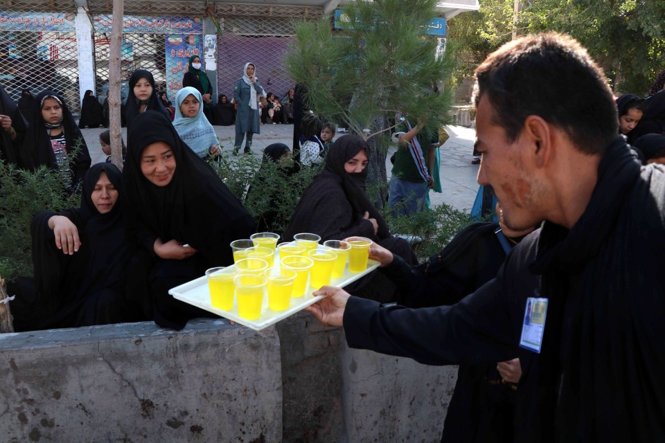  A man in Afghanistan serves drinks to attendees of commemorations