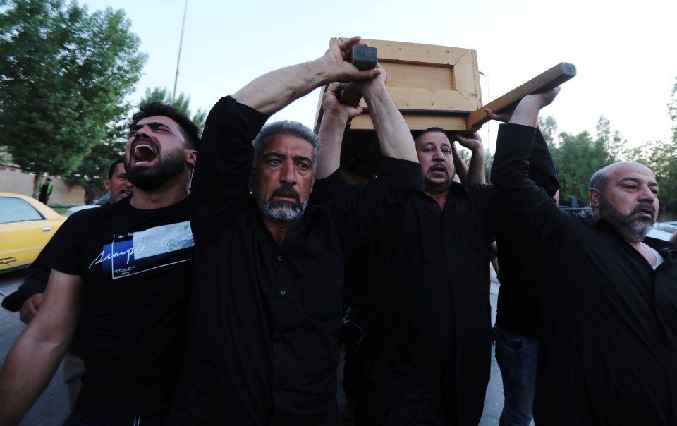  Grieving relatives of one of the victims carry a coffin through the streets