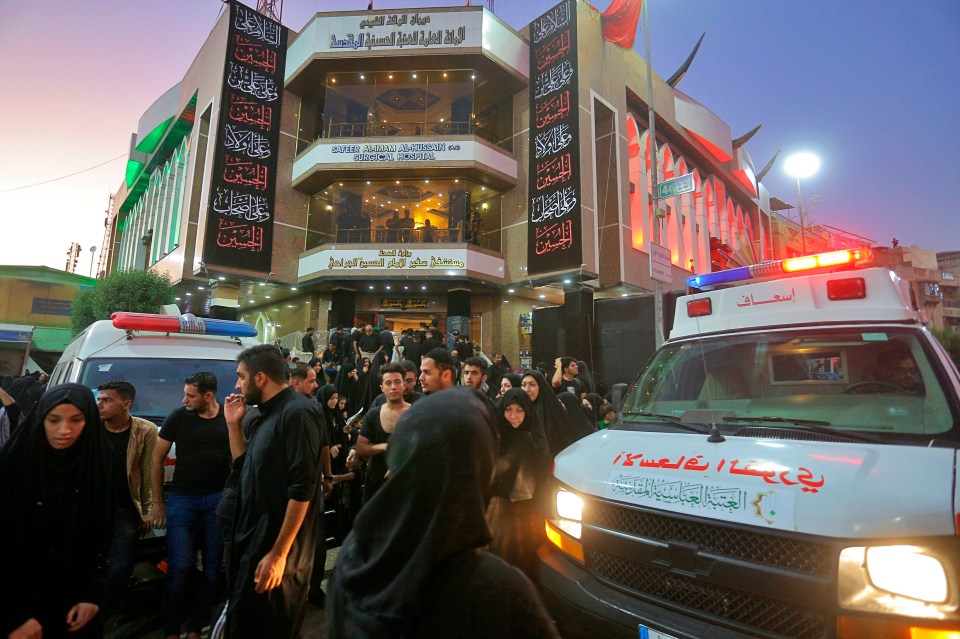  People gather outside a hospital while ambulances bring injured people