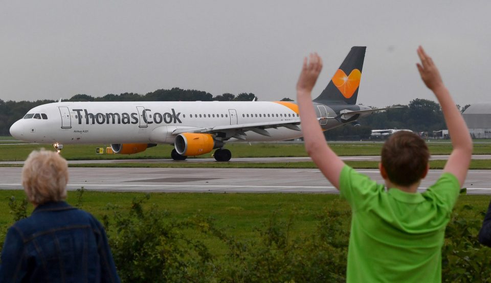  A Thomas Cook pilot's family members wave as a flight departed Manchester Airport yesterday - among the last in the company's 178-year history