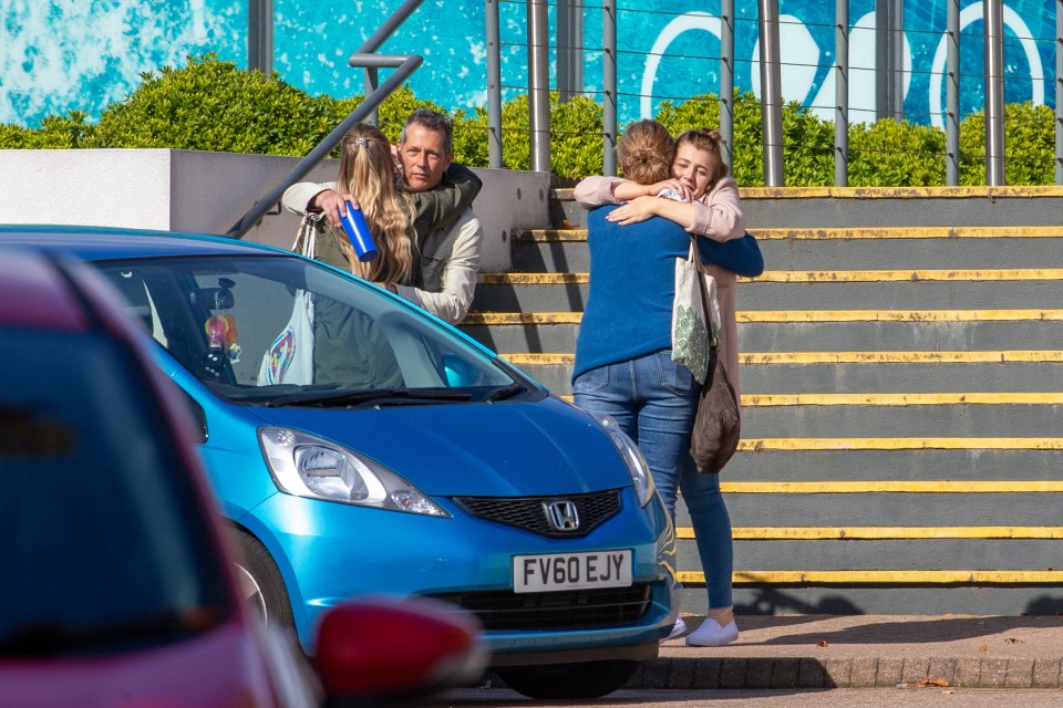  Distraught Thomas Cook employees embrace after learning that the firm had collapsed