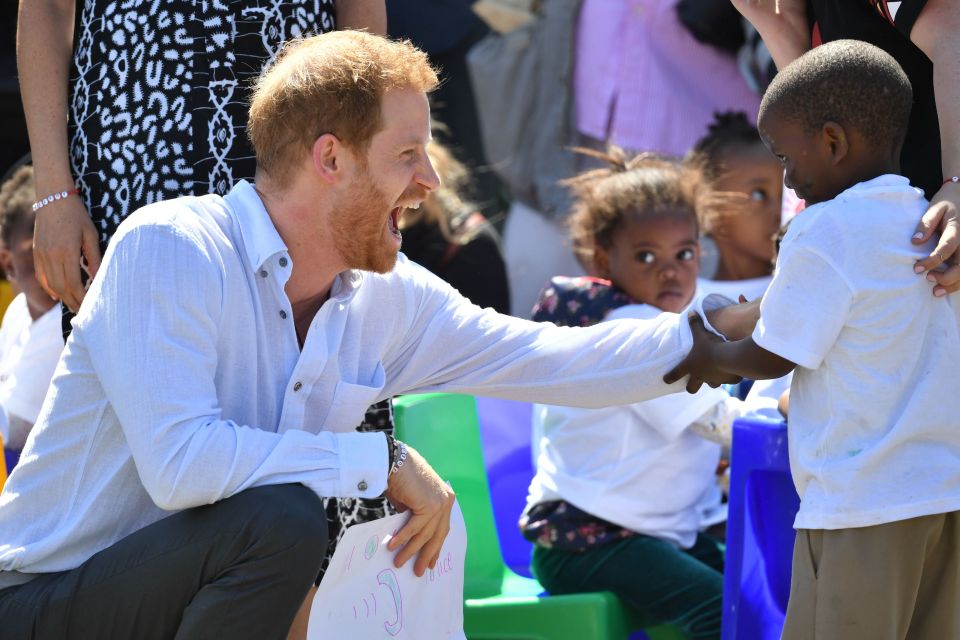  Harry tickles a little lad who looks a little star struck