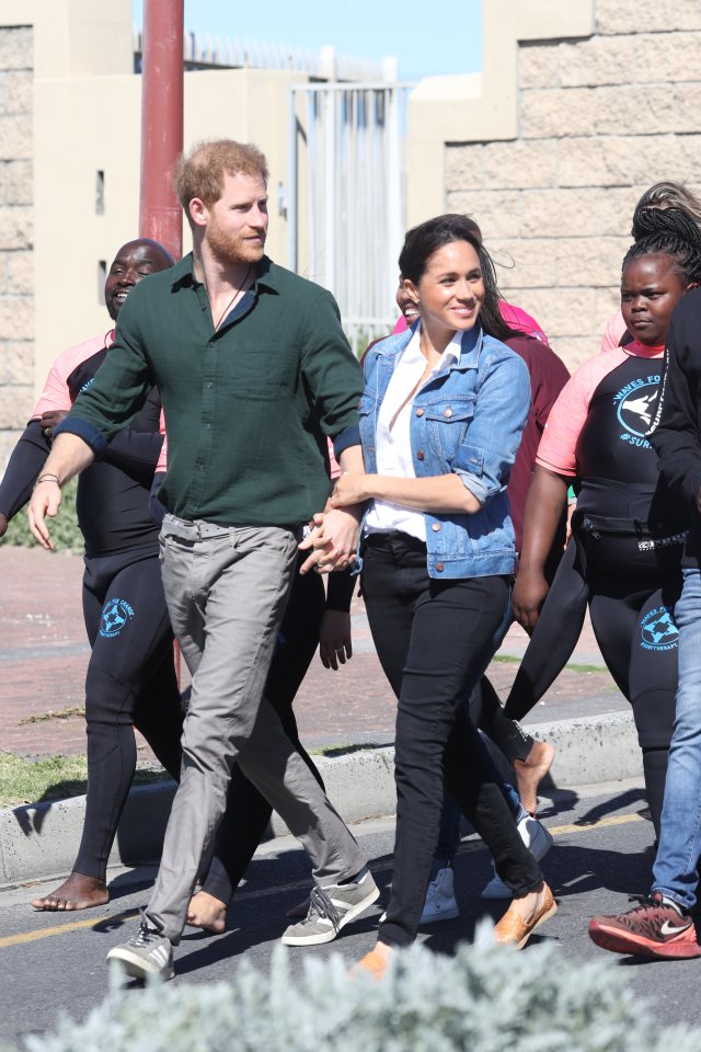  Meghan Markle and Prince Harry hold hands as they meet with young people at the surf charity