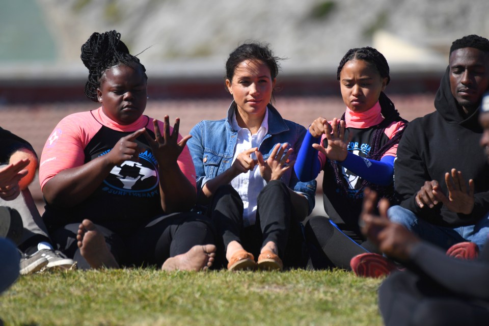  The former actress sits on the ground with some young women benefited from the charity