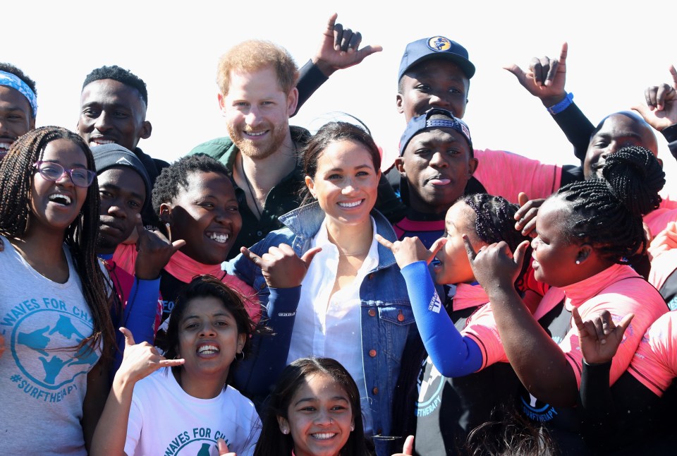  Meghan Markle and Prince Harry grin alongside young members of the charity