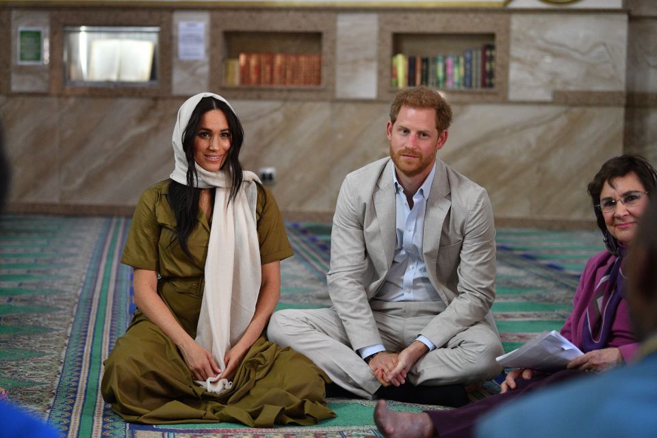  Prince Harry and Meghan Markle sit together at the mosque to listen to locals' stories