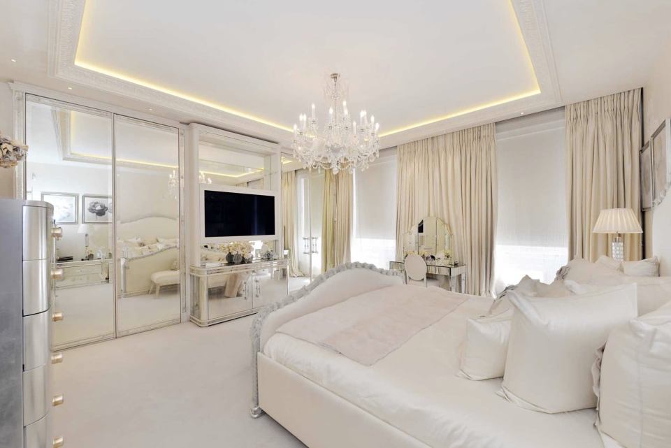  It has a large TV and mirrored wardrobes with a massive chandelier