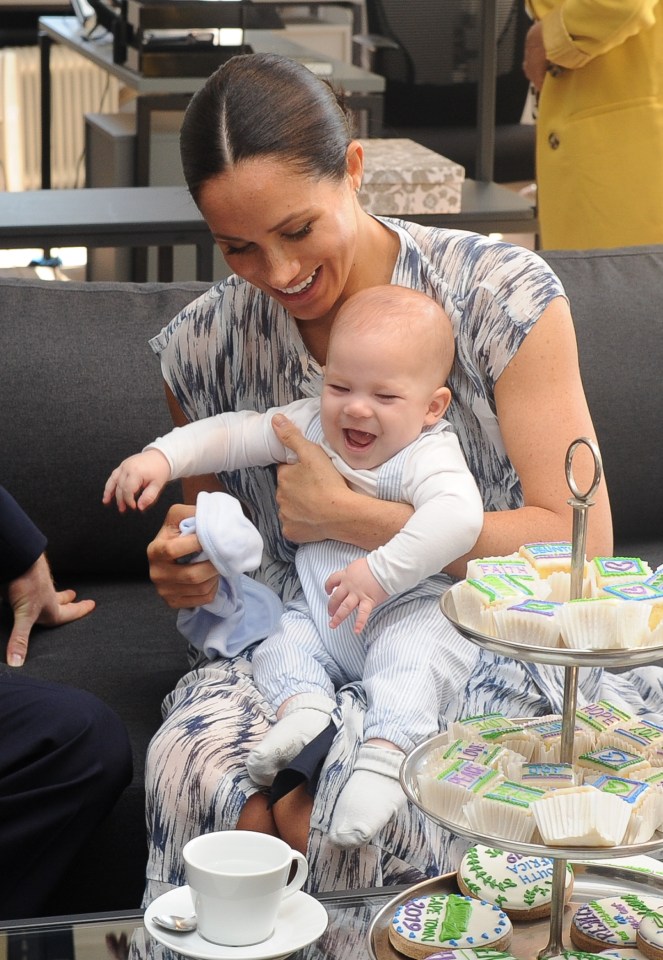  Archie giggles as mum Meghan cradles him in her arms