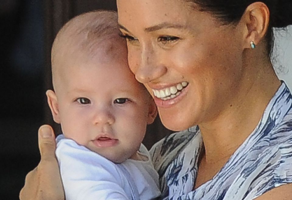  Meghan beams as she holds her little boy close