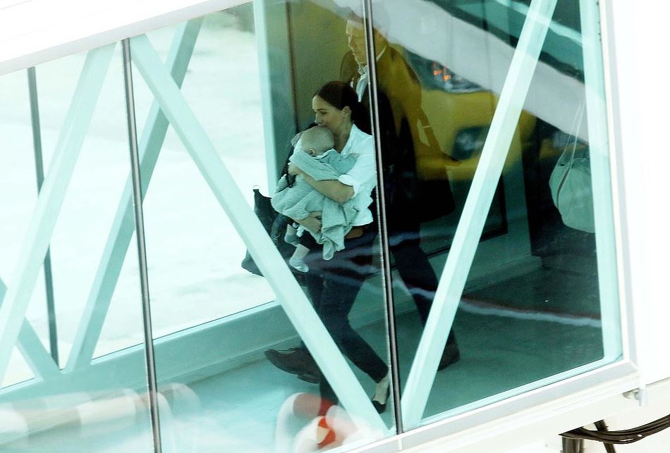  Meghan with baby Archie as they board their British Airways flight to Johannesburg yesterday - the latest in a series of candid snaps of the infant royal