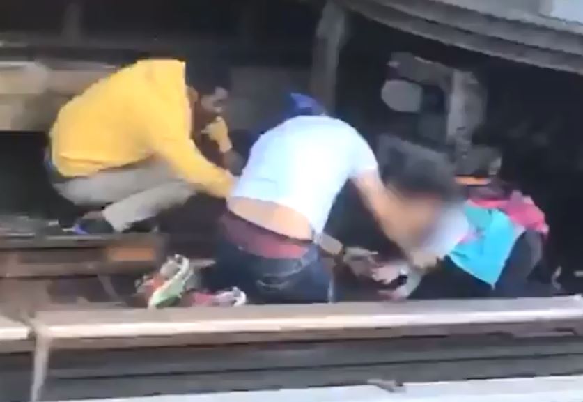  This is the heroic moment two passengers rescue a young girl from underneath a train