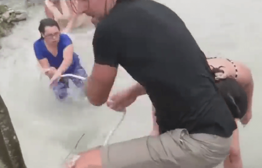  A man helps drag the group onto dry land in the Bahamas