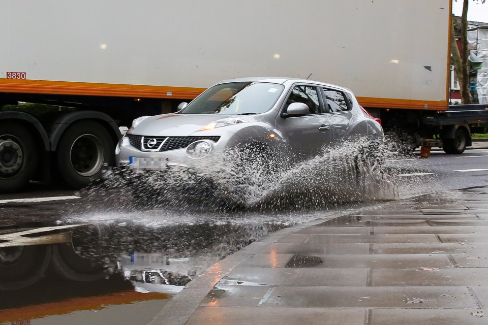  A motorist makes their way through Tottenham, North London, following heavy rainfall