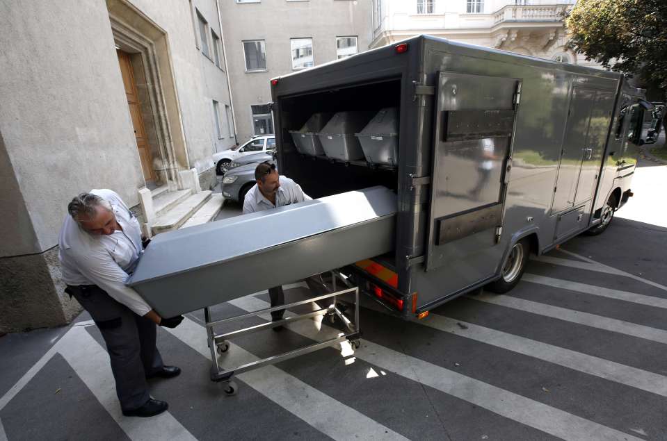  Coffins with bodies of migrants who died in an abandoned lorry are unloaded from a van in 2015