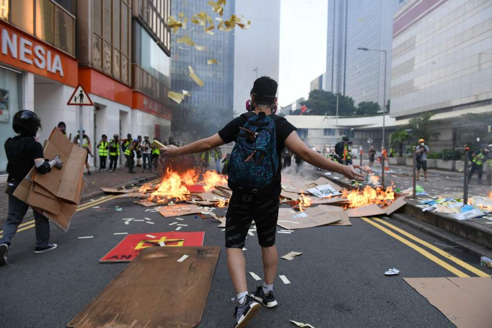  A protester throws ceremonial 'joss paper', used in memory of those who died for democracy