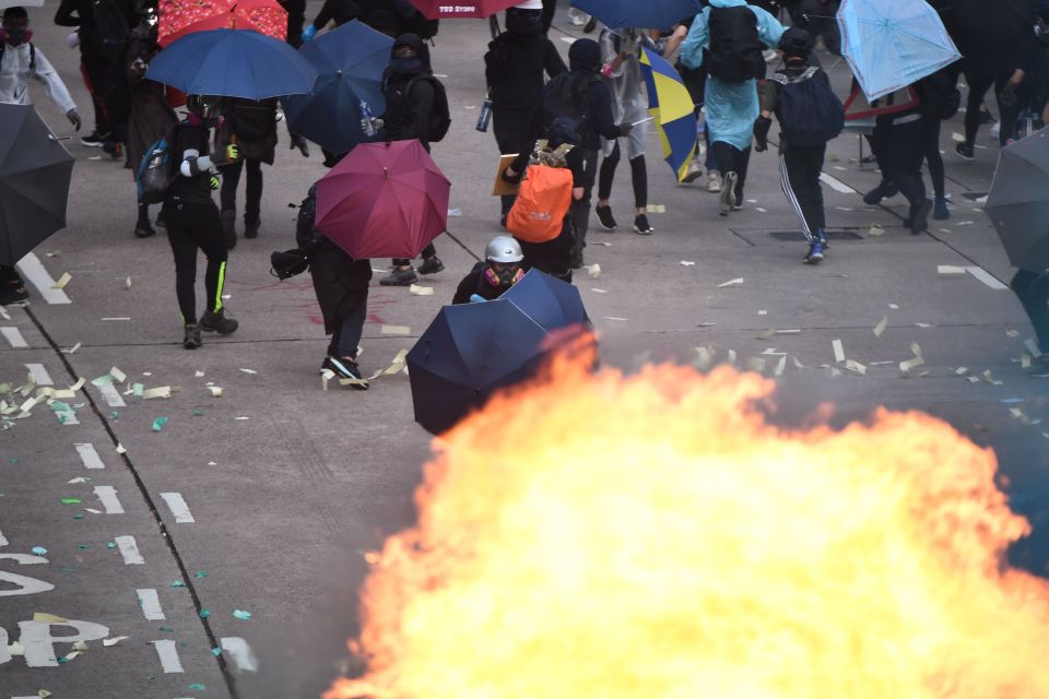  A protester charges with umbrellas as violent protests take place in the streets of Hong Kong