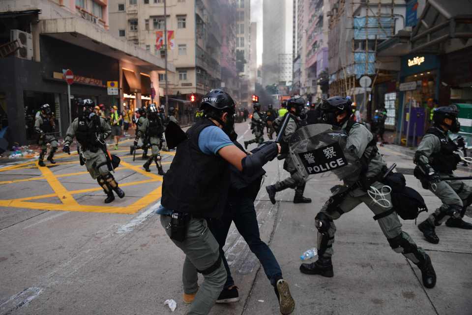  Hong Kong police chase down a protester in the street during demonstrations in the Wanchai district