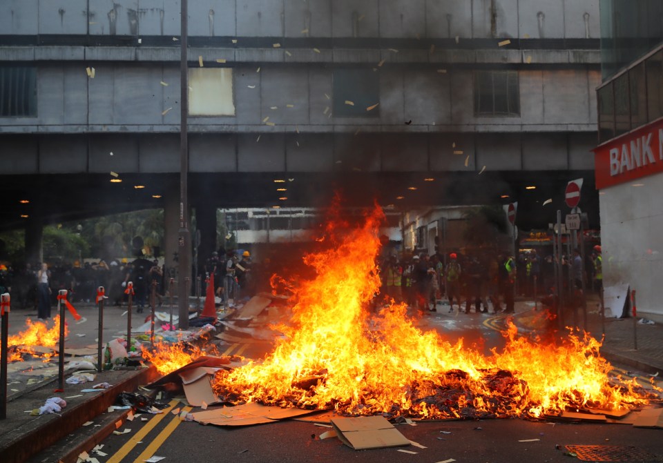  Protesters set cardboard boxes on fire at a road during protests on National Day