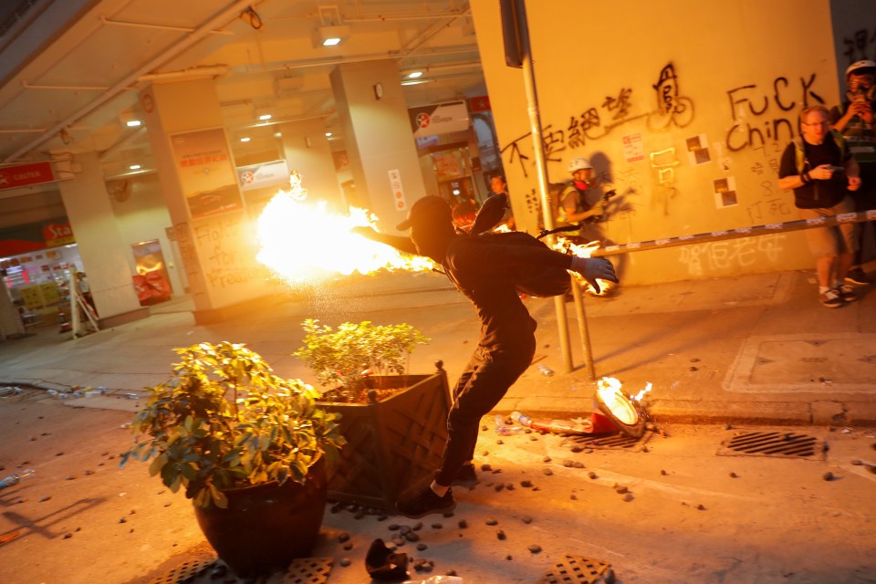  An anti-government protester throws a molotov cocktail during a protest