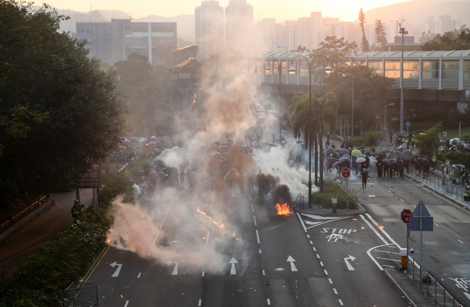  The sun sets as tear gas smoke rises from a road occupied by anti-government protesters on National Day in Hong Kong