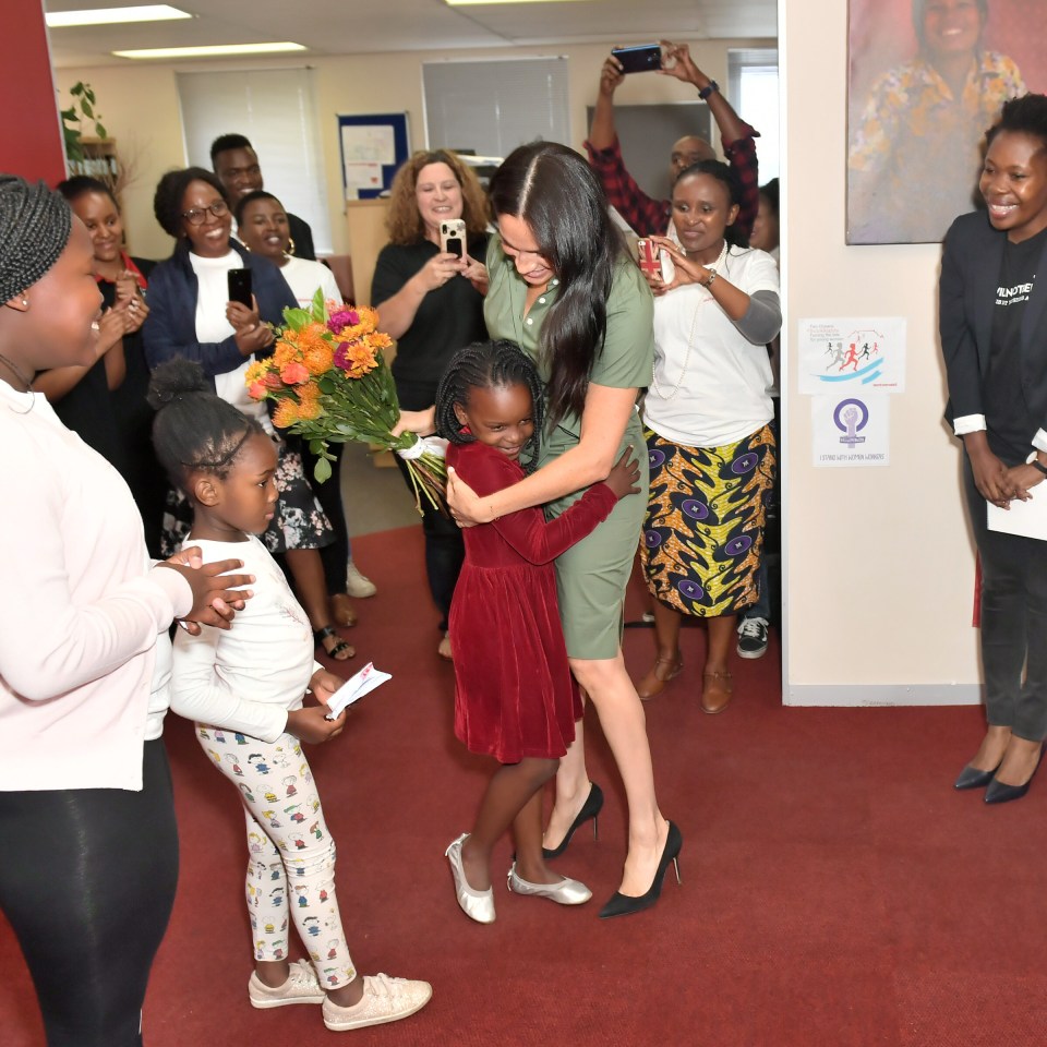  Meghan Markle embraced a young child during the event on her penultimate day of the royal tour