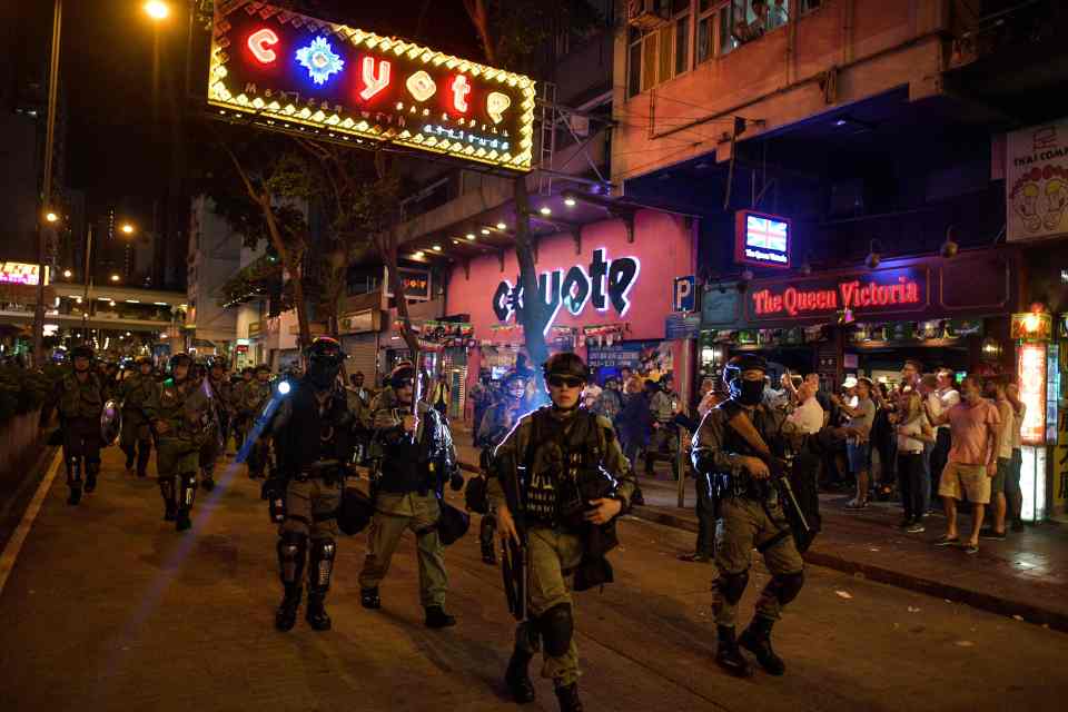  Riot police march in Wan Chai district, an area popular among tourists