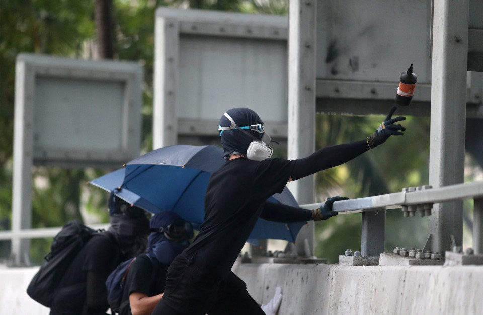  A protester hurls a missile in the direction of the police in Hong Kong