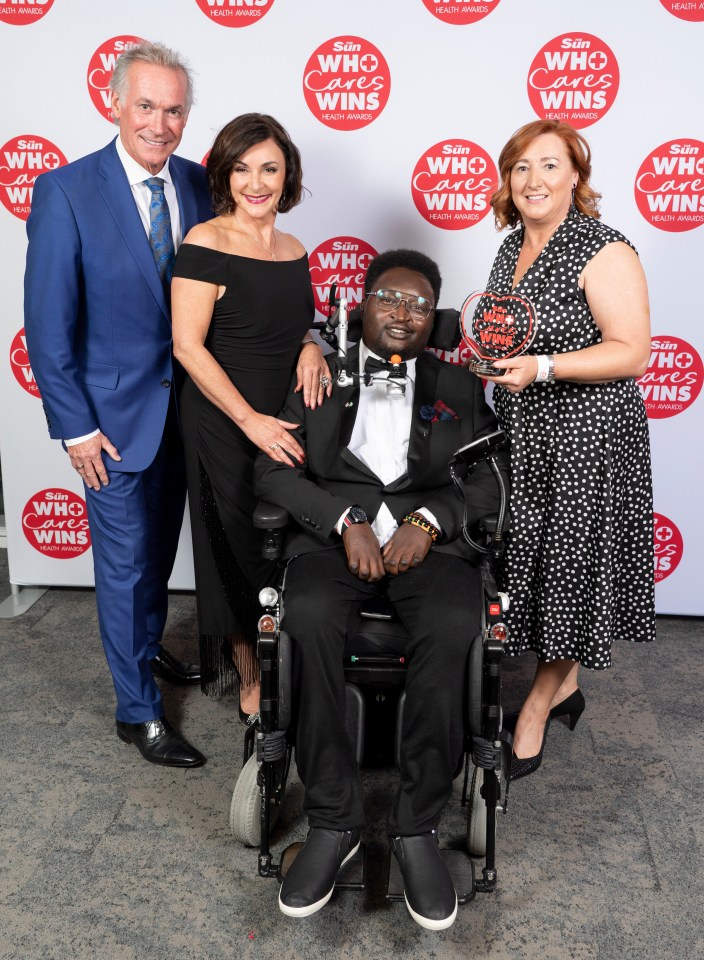  Ify Nwokoro, of Therapeutic Care Volunteers at South Tees NHS Foundation Trust, collects the Unsung Hero award from Dr Hillary Jones and head Strictly judge Shirley Ballas