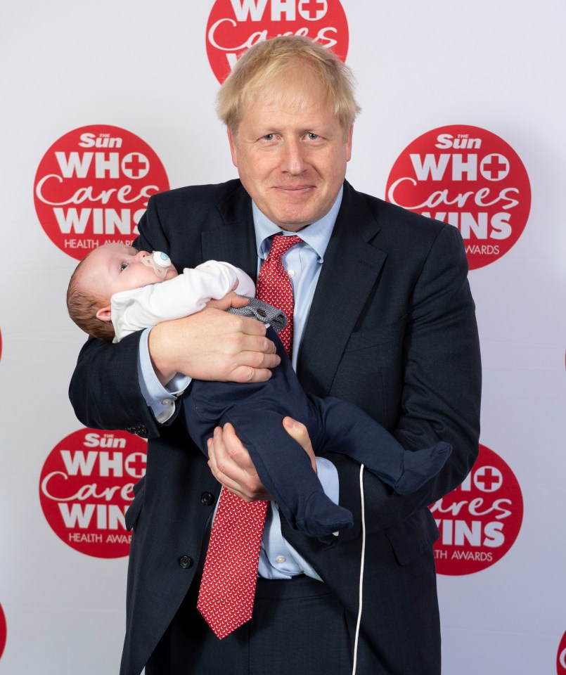  Mr Johnson holding baby Logan Clifford whose life was saved by NHS porters Nick Evans and Ruth Lowe