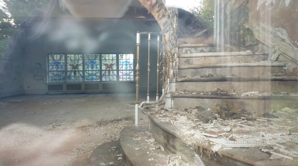  Taken through a window by one of the urban explorers, the wallpaper has peeled and the staircase is crumbling away