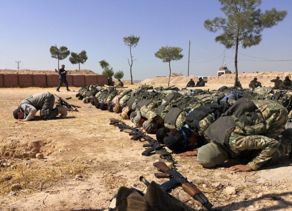  Members of Syrian National Army (SNA) pray on the side of the road