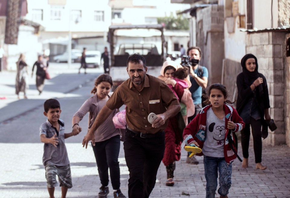  The Kurdish forces hit back... People run to take cover after mortars fired from Syria, in Akcakale, Turkey