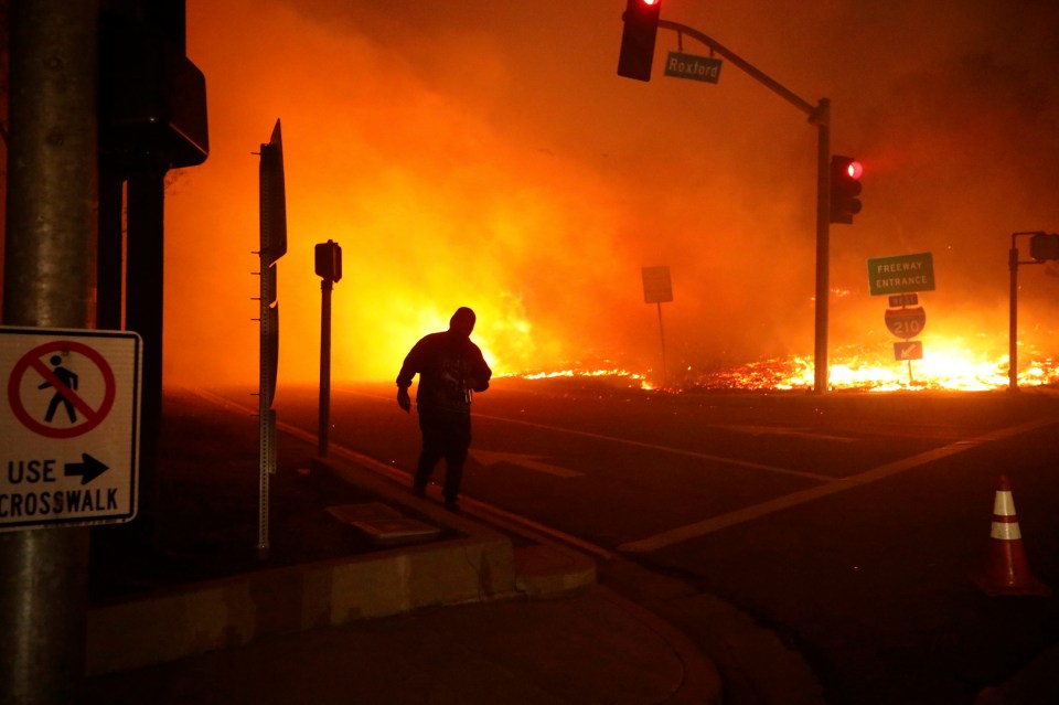 A bystander runs from the Saddleridge fire in Sylmar