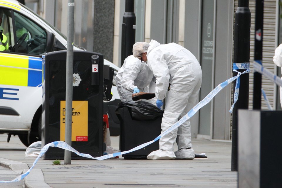  Forensic officers look at items on the floor after the Manchester knife attack