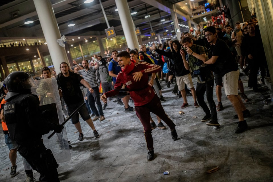  Pro-Catalan protesters clash with riot cops at Barcelona airport last night after a verdict in a trial over a banned independence referendum