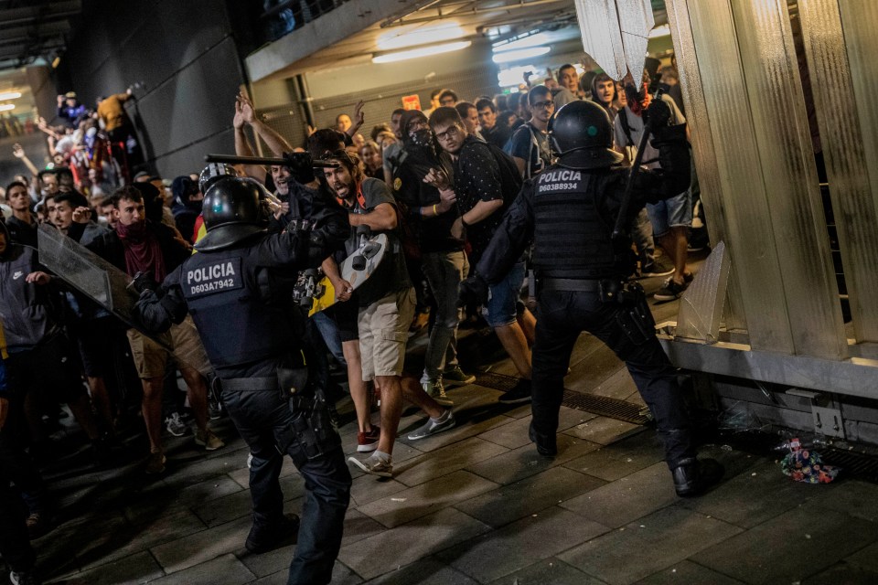  Riot police aim their batons amid angry scenes in Barcelona last night