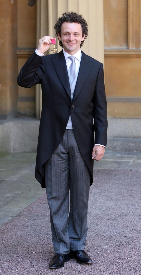  The star posing with his medal after being 'shoved' by The Queen