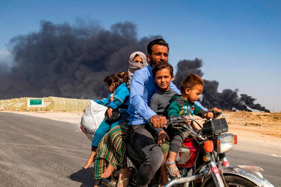  A family flees by motorbike from the town of Ras al-Ain along the border with Turkey