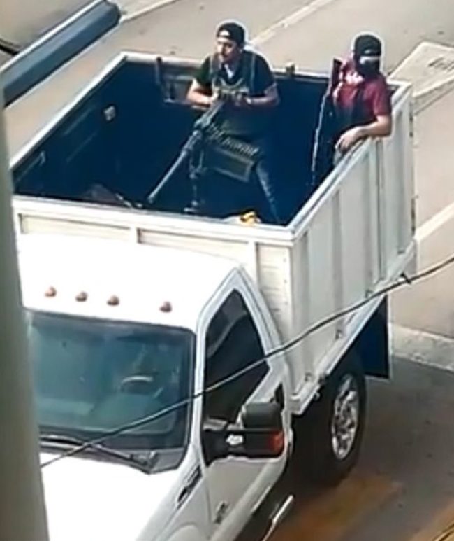 Gang members ride through the city with a mounted machine gun