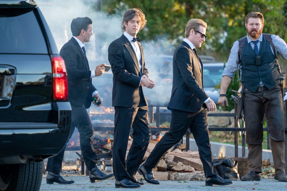  Guests walk past the open wood-fire barbecue as they make their way to the wedding