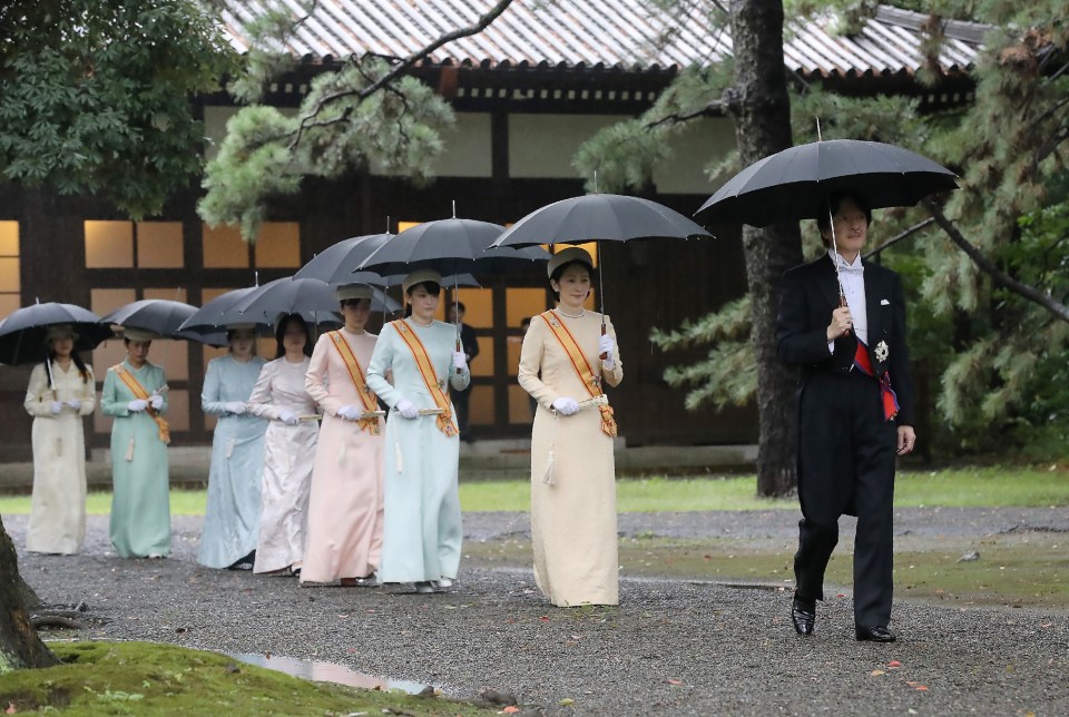 Japan’s Prince Akishino and Princess Kiko walk in a line towards the ceremonial site