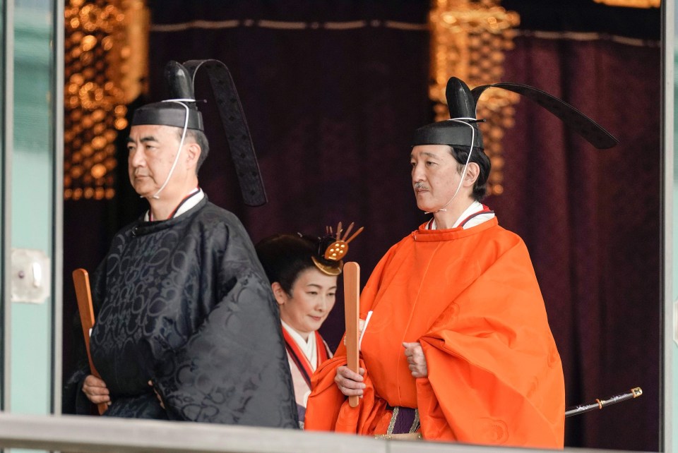 Japanese Crown Prince Akishino (right) leaves the ceremony hall with Crown Princess Akishino (centre) after his brother Emperor Naruhito proclaimed his enthronement